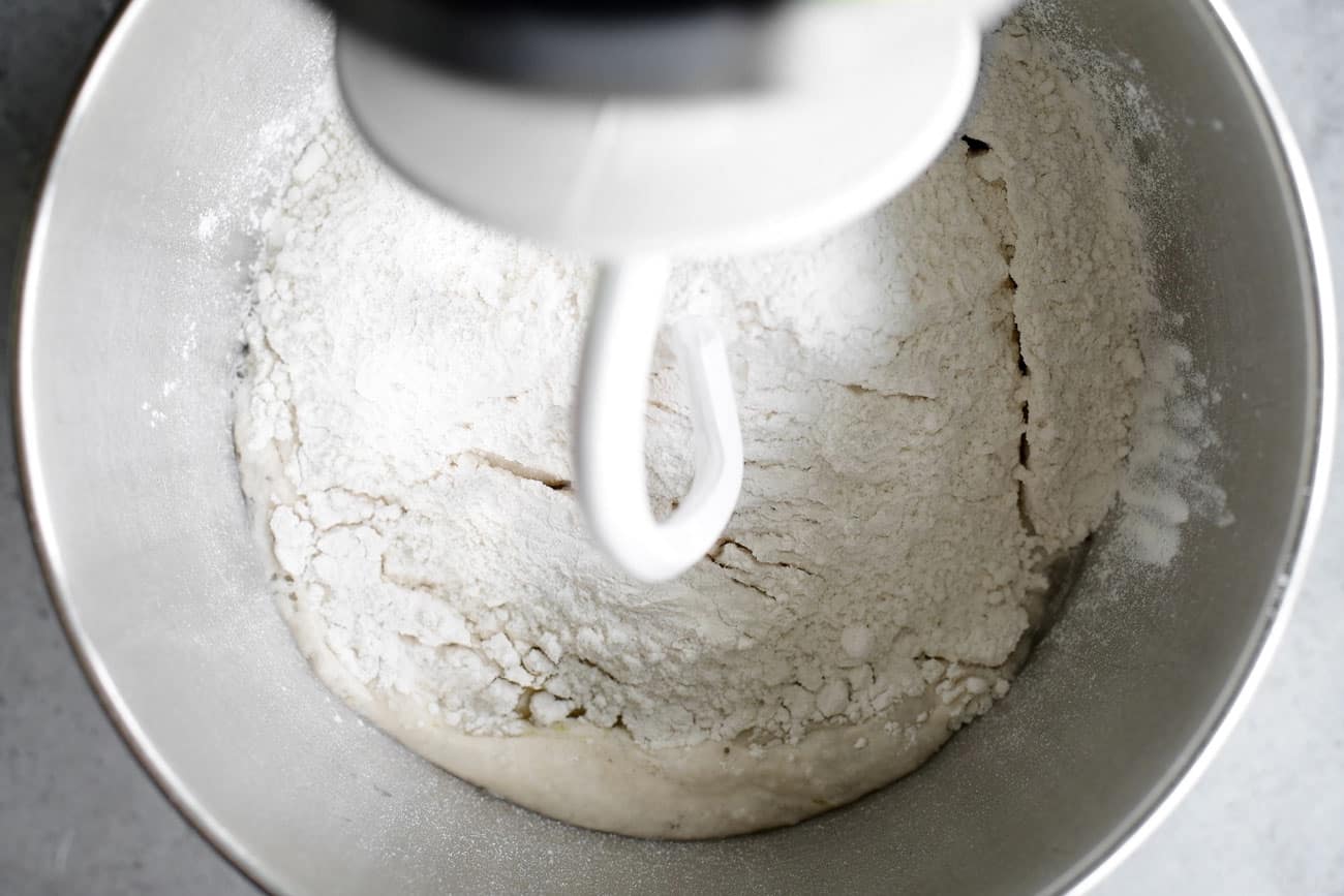 flour in a stand mixer bowl with a hook attachment