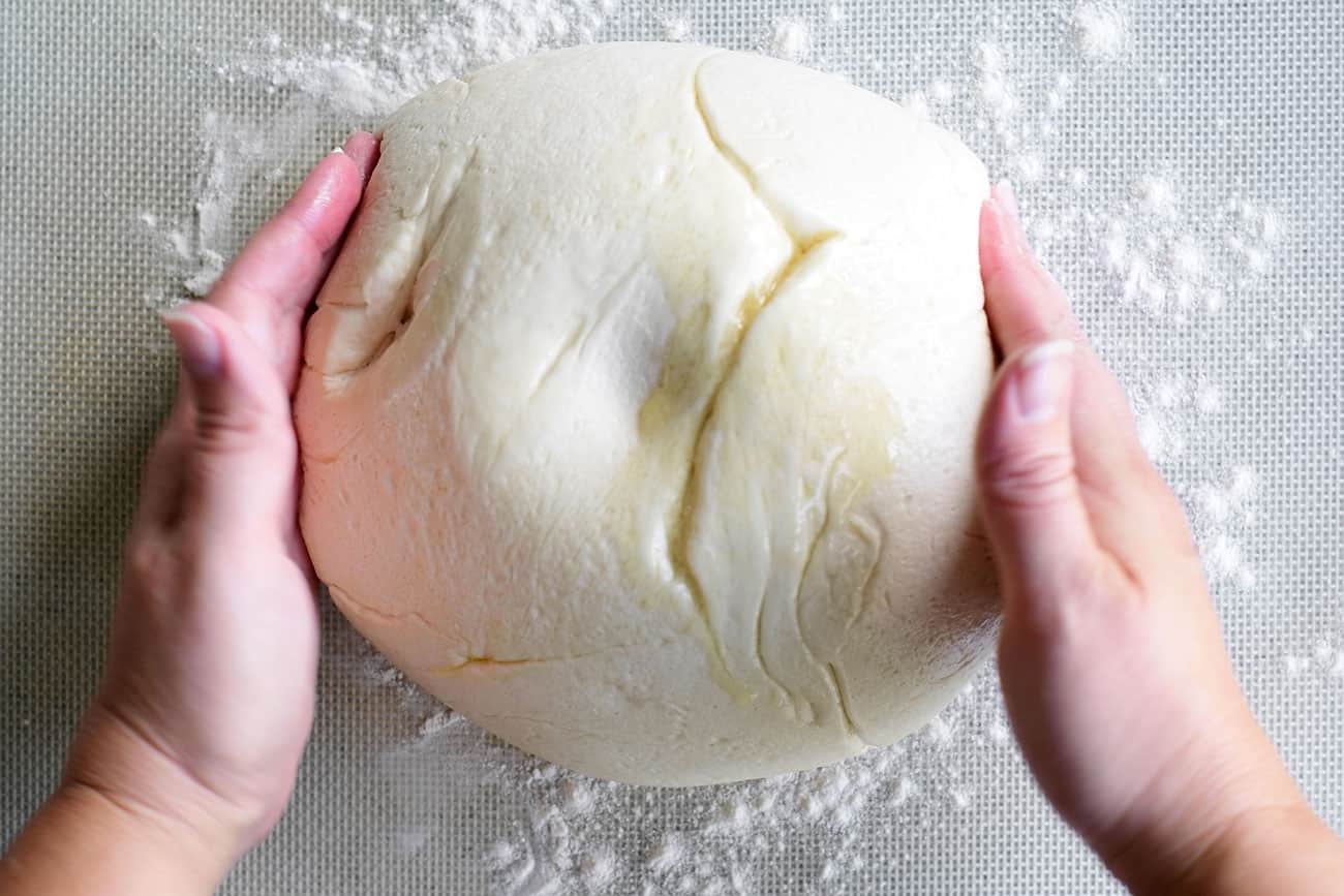 hands shaping pizza dough