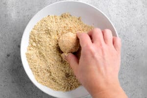 coating a ball of cheese with breadcrumbs