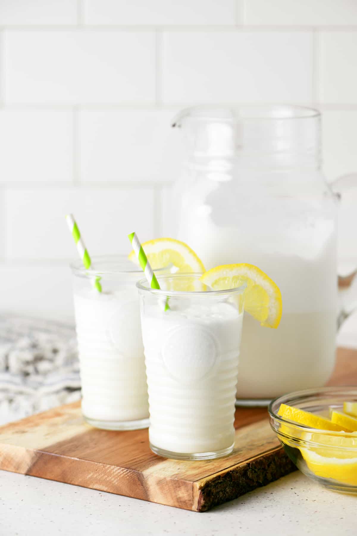 two cups of lemonade whip on a cutting board