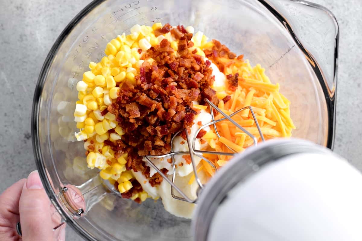 mixing mashed potatoes, corn, cheese, and bacon