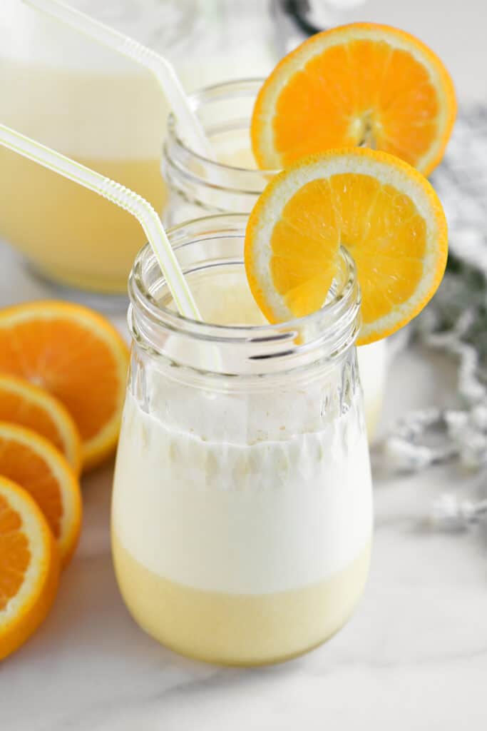 two cups of orange whip garnished with orange slices