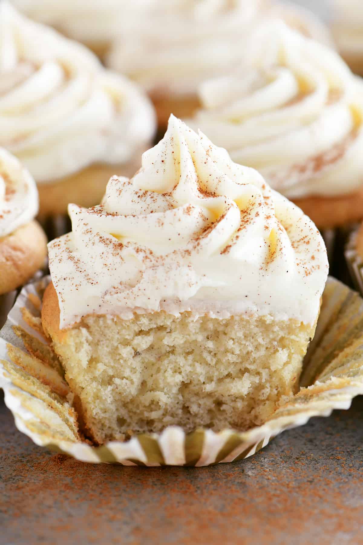 a frosted banana cupcake with a bite out of it