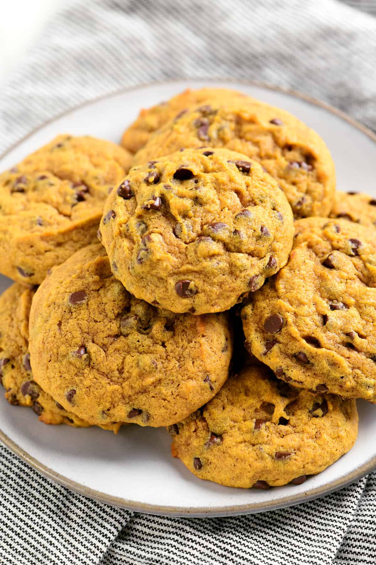 a plate with several pumpkin chocolate chip cookies on it