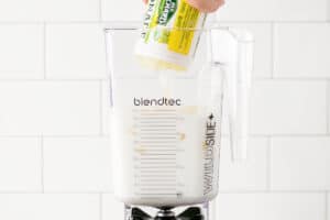 adding frozen lemonade to the blender