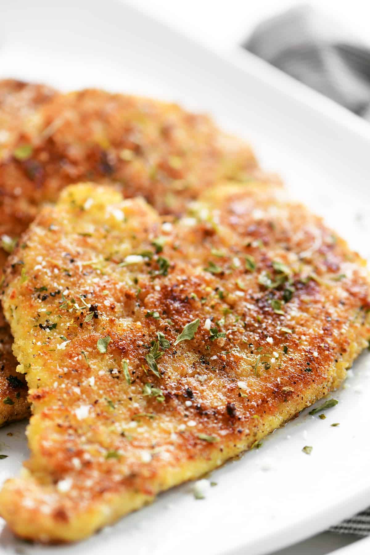 side view of parmesan crusted chicken on a platter