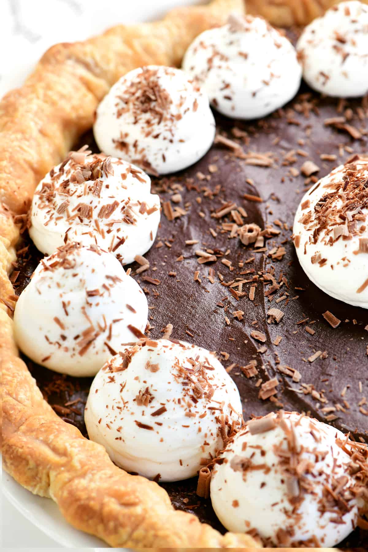 dollops of whipped cream on a chocolate pie