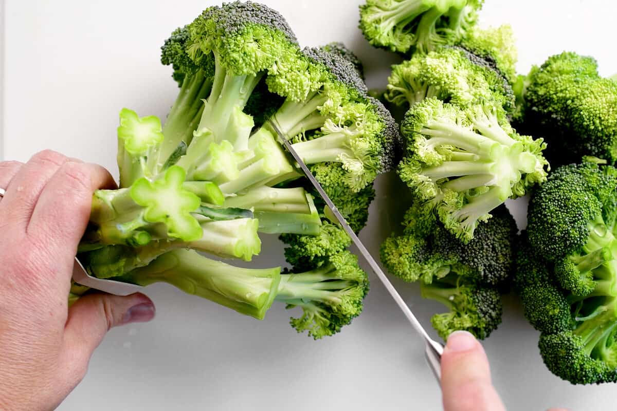 hands cutting stalks of broccoli