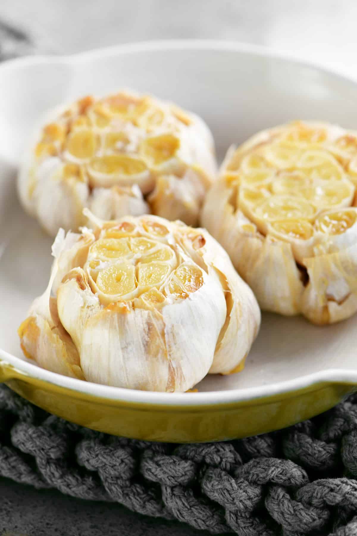 roast garlic heads in a yellow pan