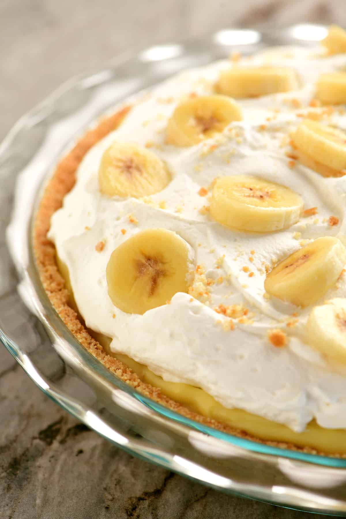 side view of a banana cream pie in a glass pie dish