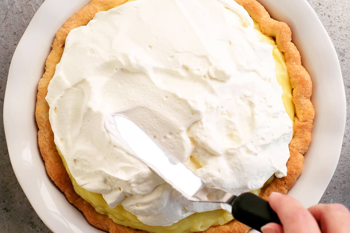 smoothing the whipped cream on top of the pie