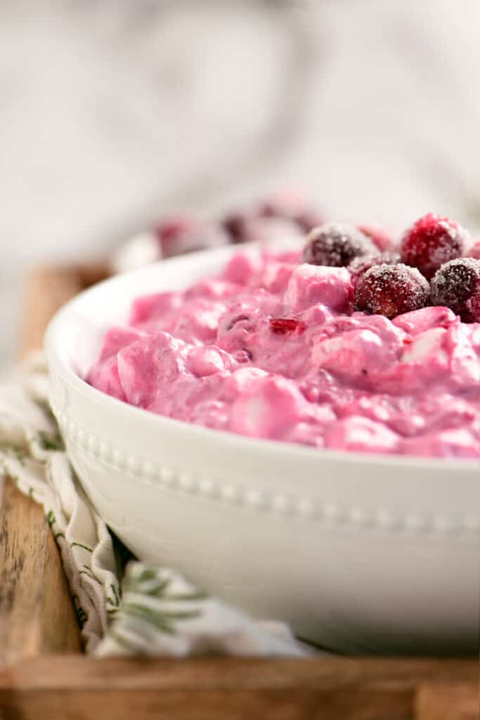 cranberry salad in a white bowl on a wooden tray