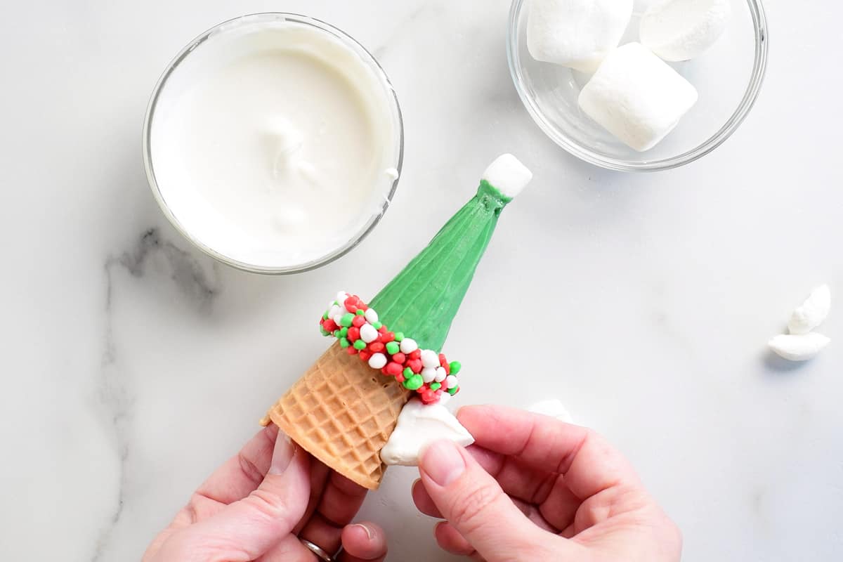 adding ear shaped marshmallows to the elf Christmas cone