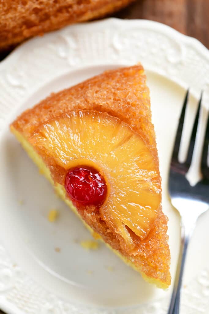 a slice of pineapple upside down cake on a plate with a fork