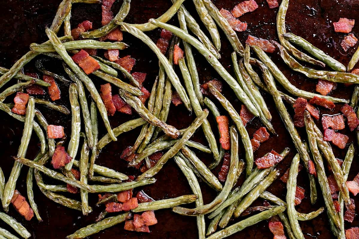 roasted green beans and bacon on a pan with seasoning