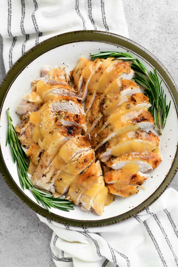 platter of sliced slow cooker turkey breast with gravy