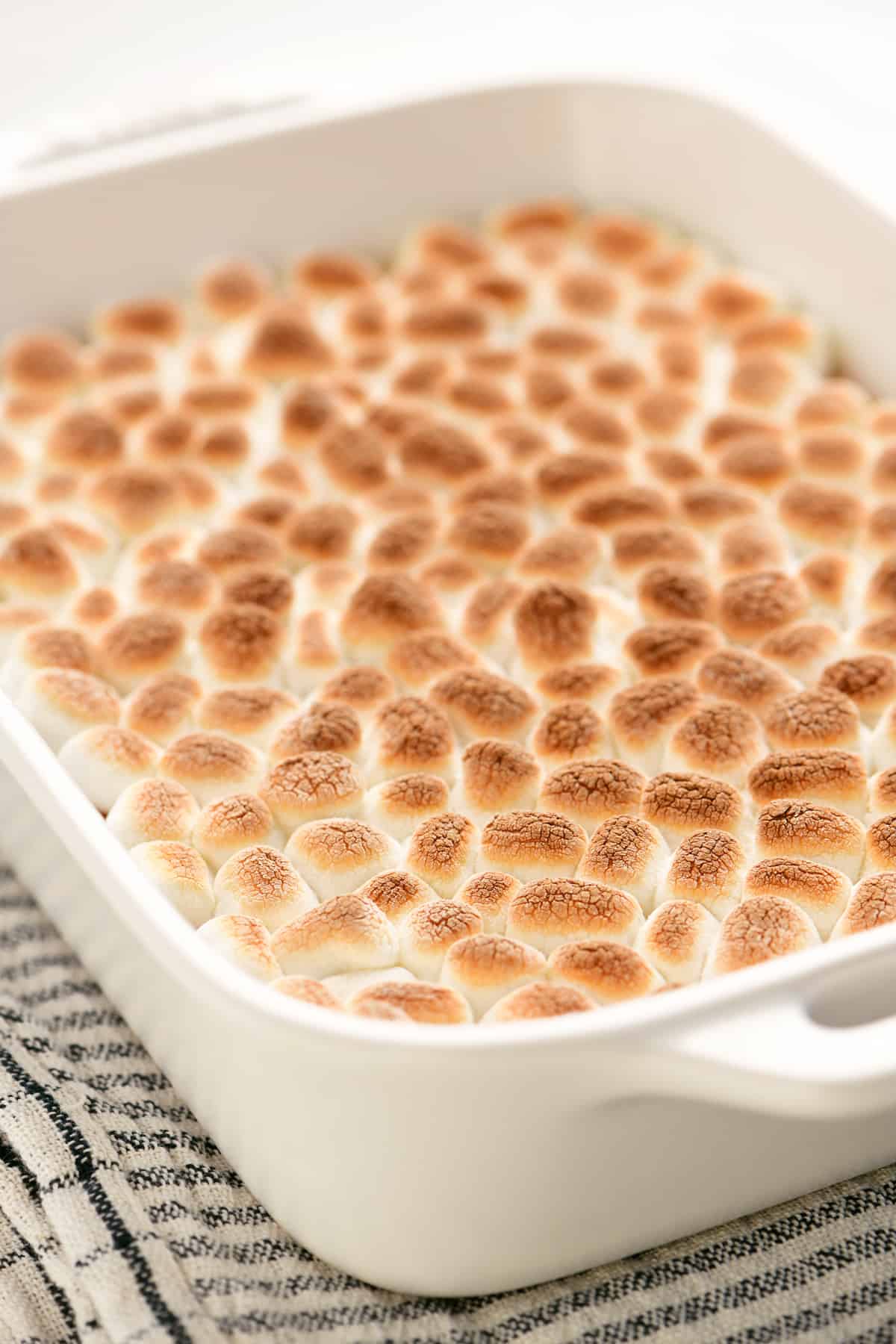 toasted marshmallows covering sweet potatoes in a white dish