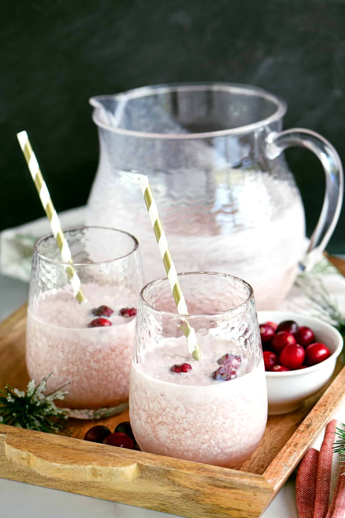 Frosted cranberry punch on a tray with glasses.