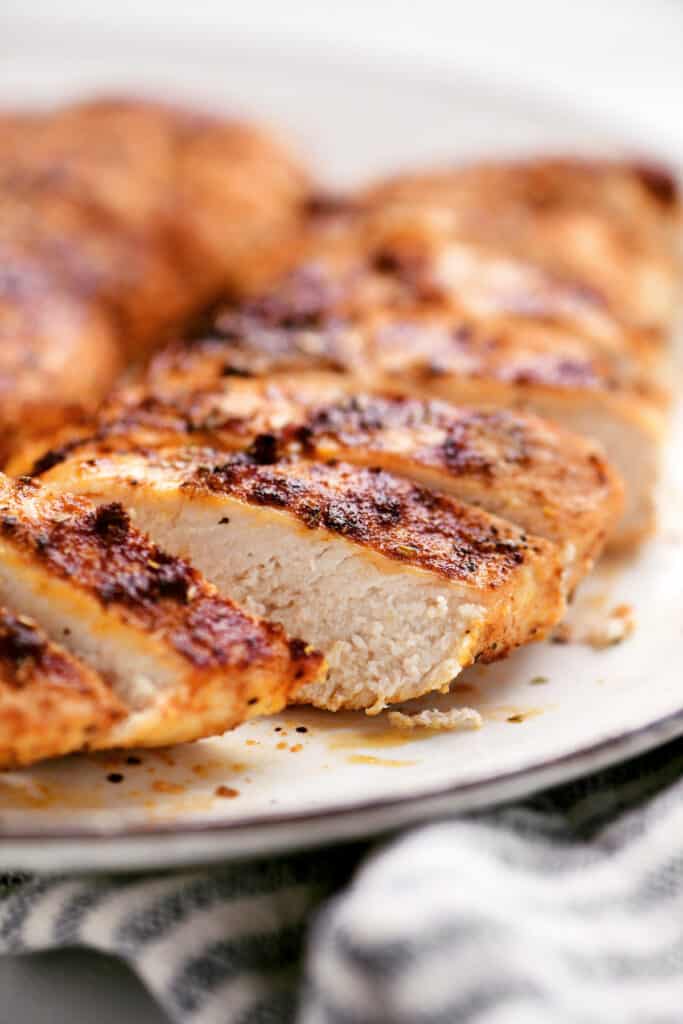 close up of a seasoned air fryer chicken breast sliced on a plate