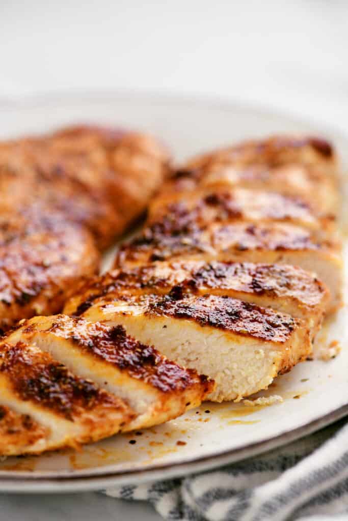 sliced air fryer chicken breast sliced on a white plate