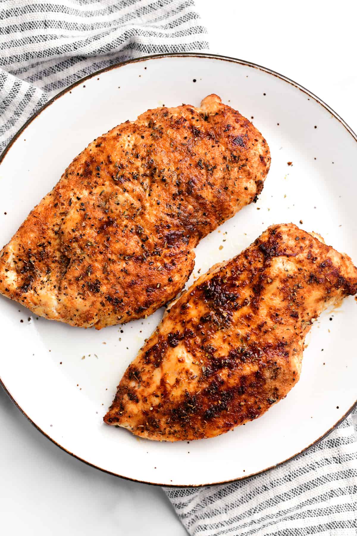 two air fryer chicken breasts on a white plate