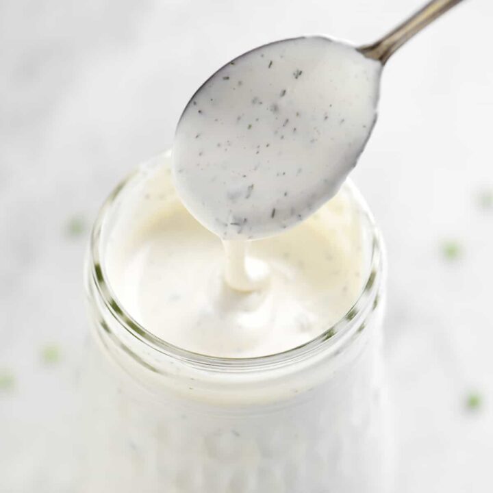 drizzling ranch dressing from a spoon into a jar