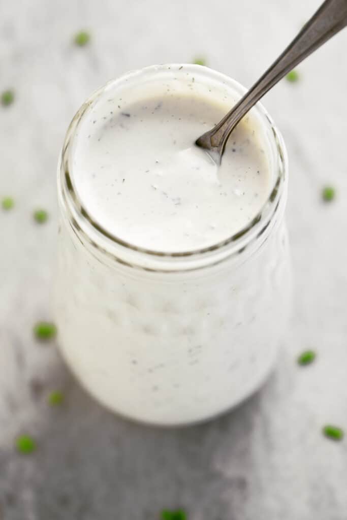 mason jar of ranch dressing with a spoon in it