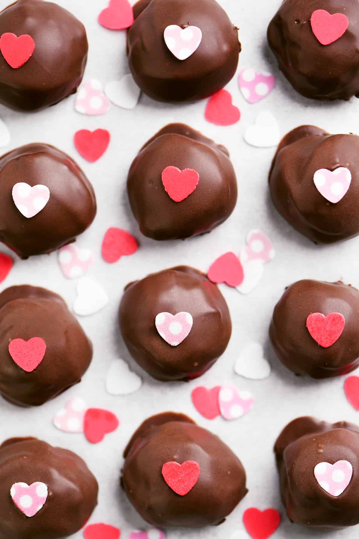a dozen chocolate truffles with heart shaped candies