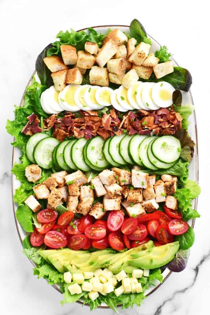 a platter with various salad toppings on a countertop