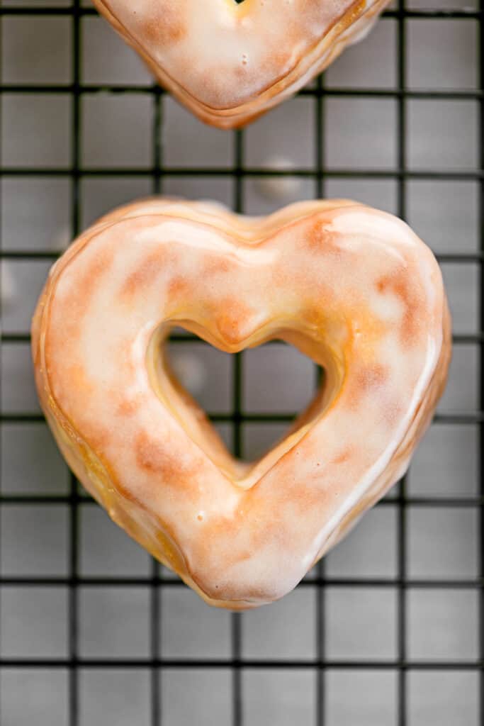 a heart-shaped glazed donut on a wire rack