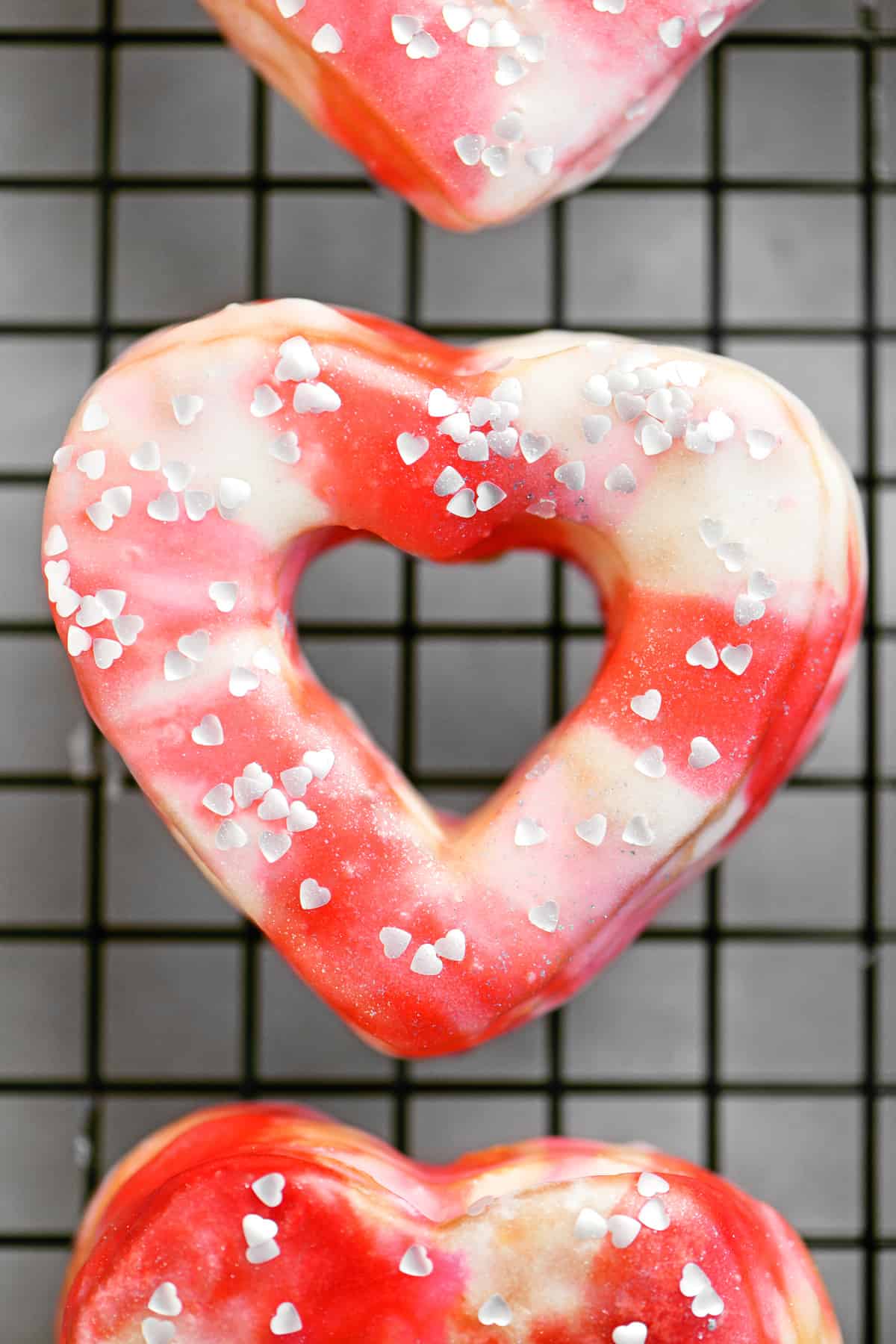 silver heart shaped sprinkles on a pink valentines donut