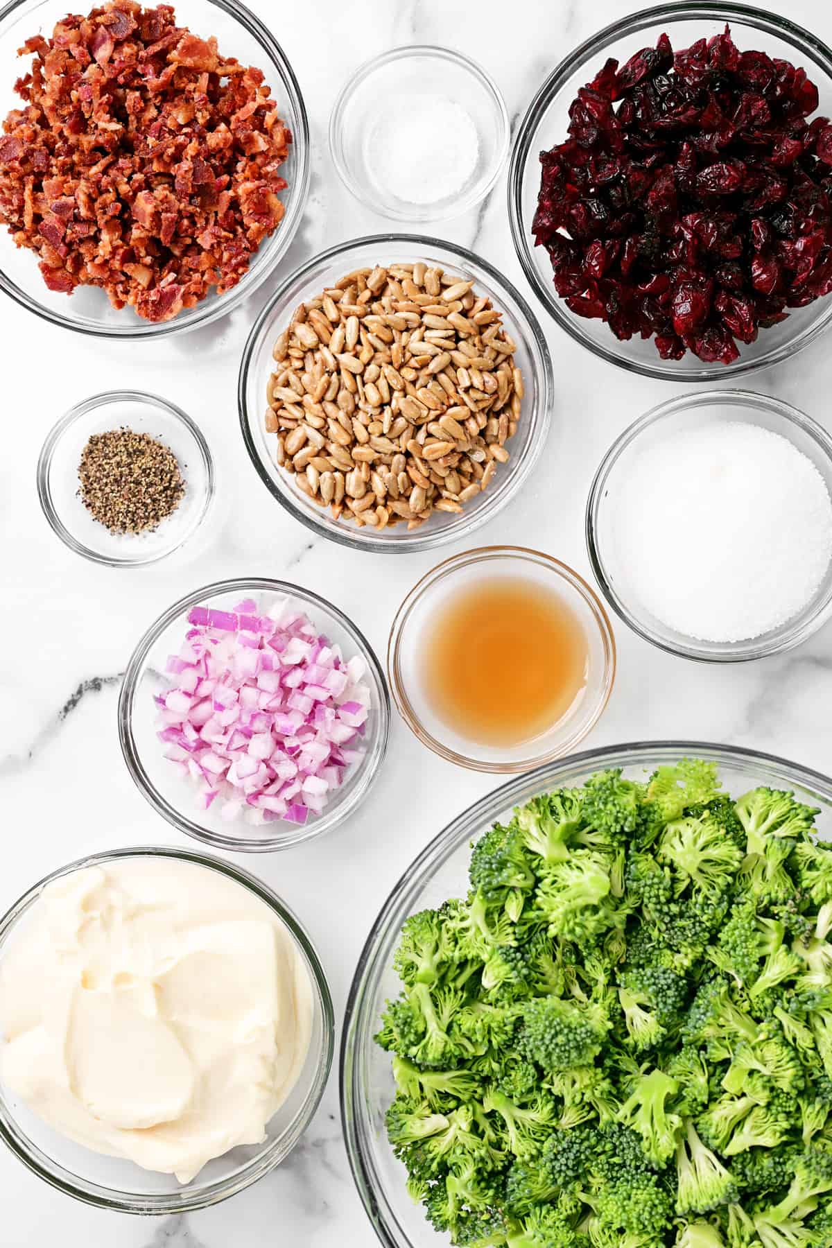 ingredients in bowls on a white marble countertop.