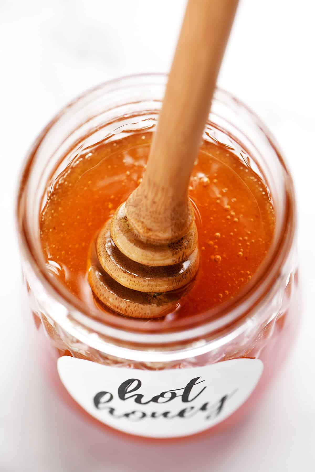 a jar of hot honey with a honey wand in it