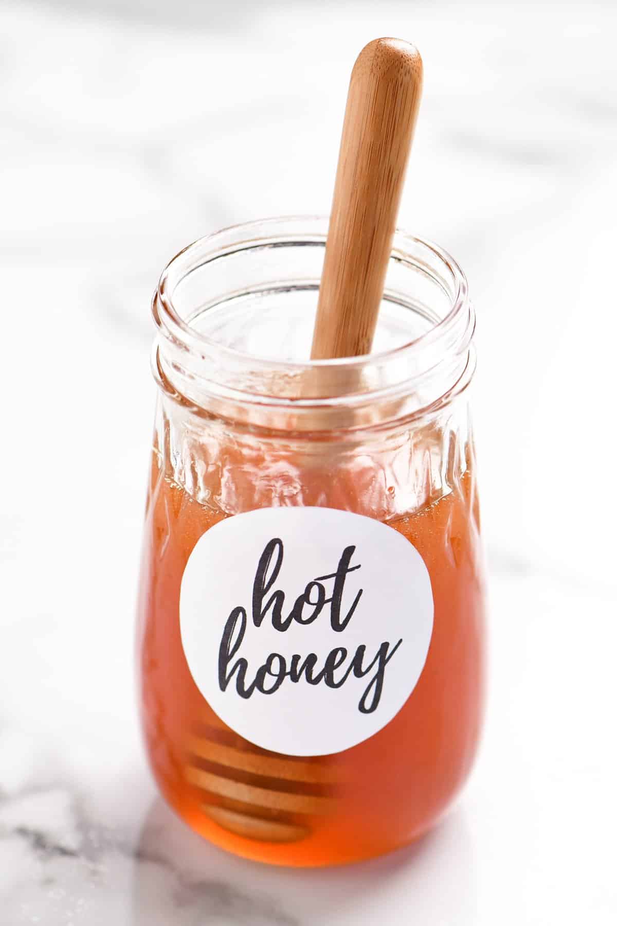 hot honey in a jar with a honey drizzler inside