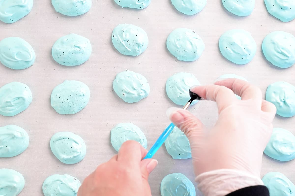 spraying speckles on meringue cookies