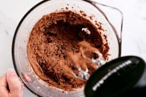 a mixer mixing the chocolate into the frosting