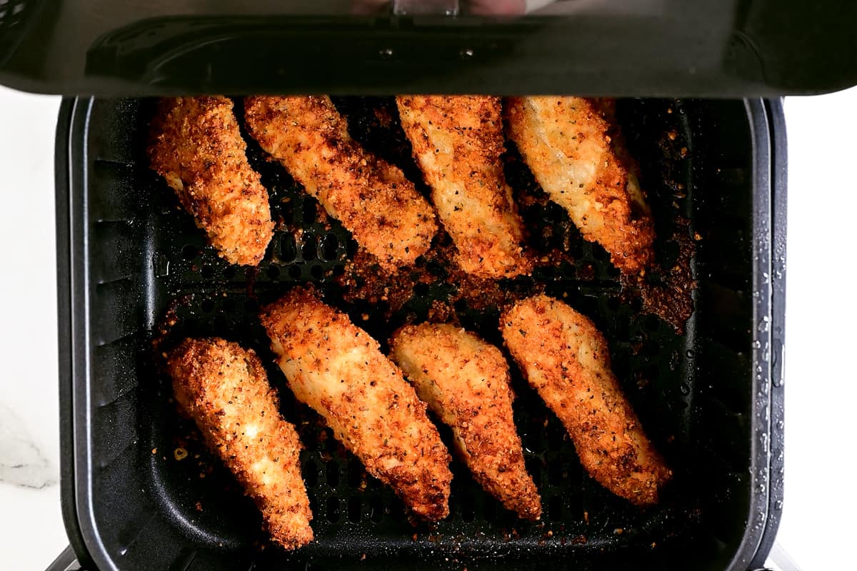 eight chicken tenders in an air fryer basket