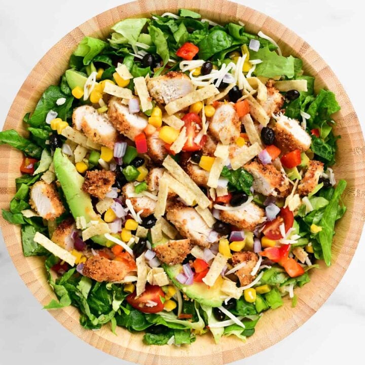 a chipotle chicken salad with tortilla strips on top