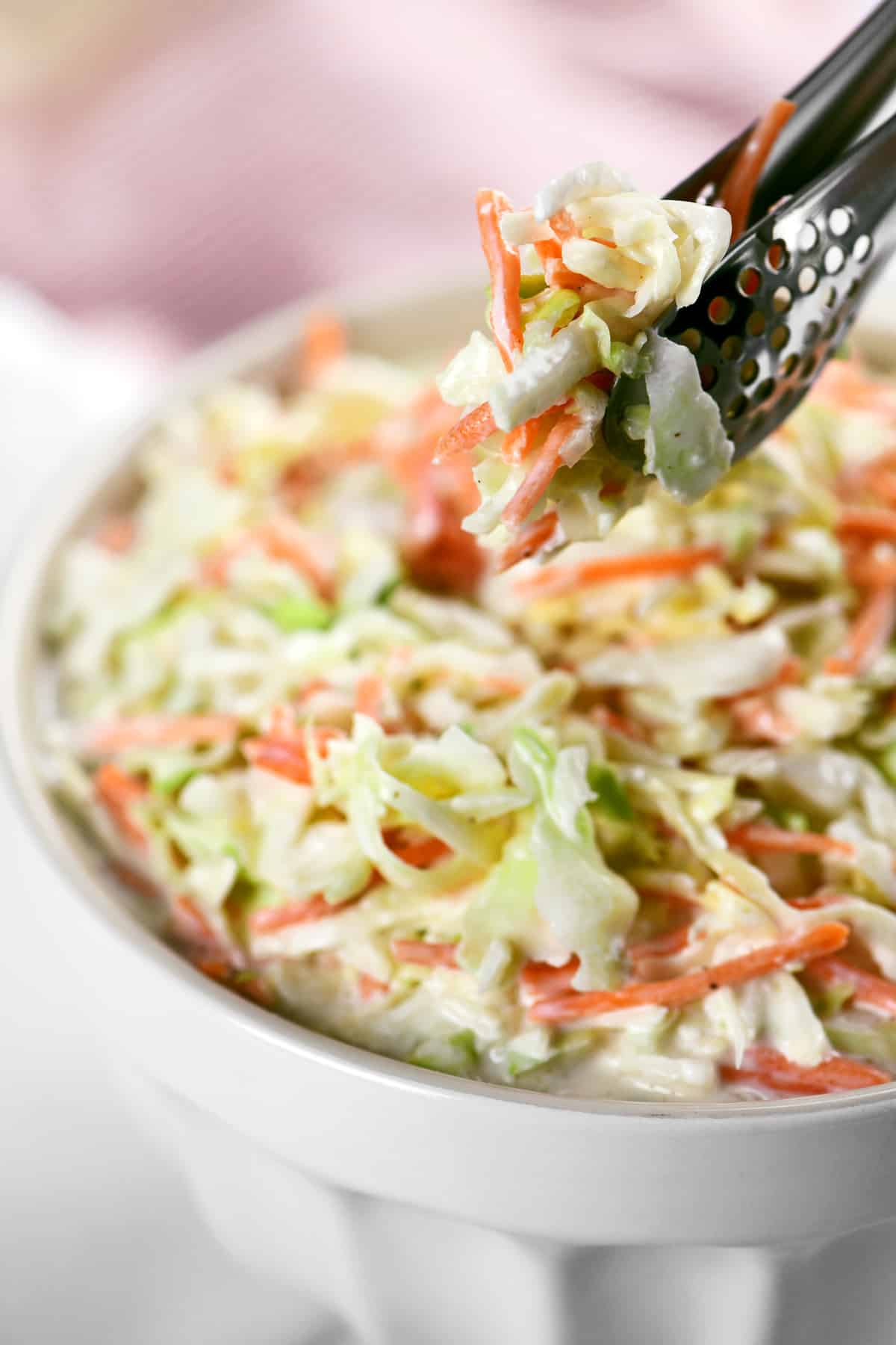 a pinch of coleslaw in a pair of serving tongs