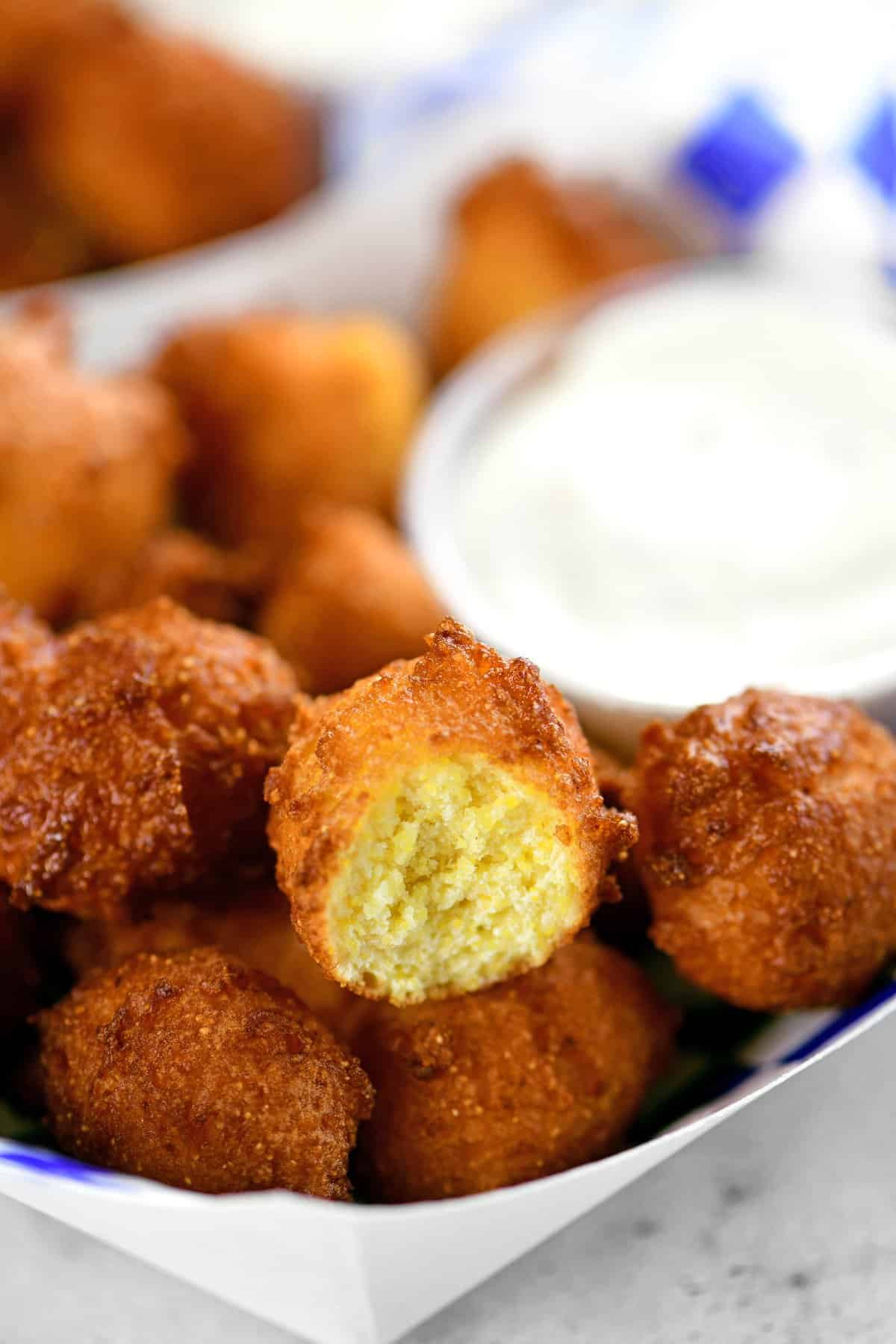 several fried hushpuppies in a paper serving tray