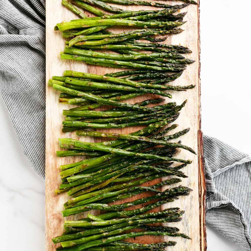 roasted asparagus on a wooden platter