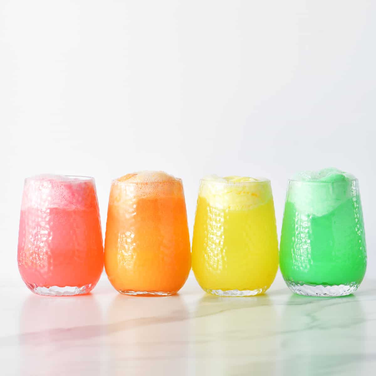 pink, orange, yellow, and green sherbet punch in cups