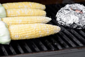 four ears of corn on a grill