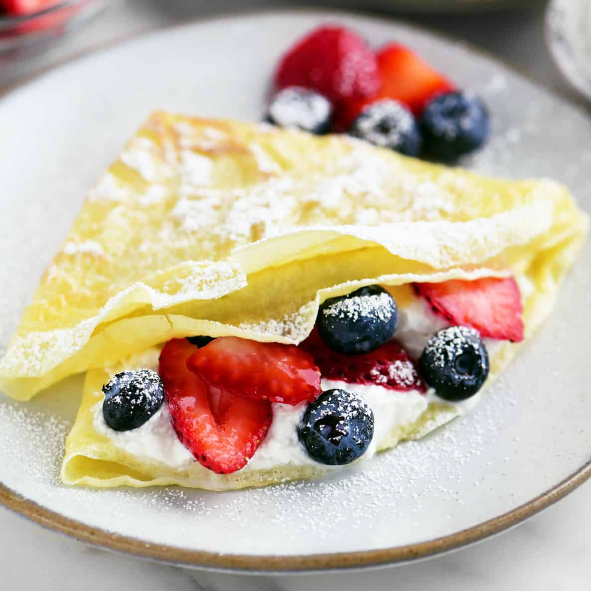 crepe filled with berries and whipped cream