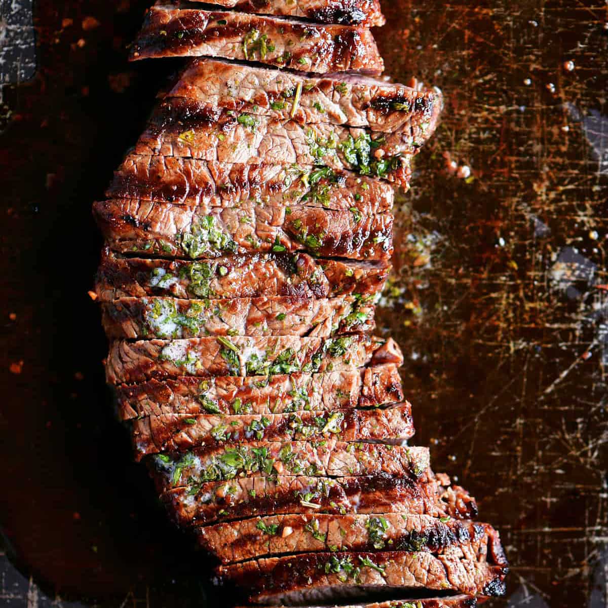 sliced steak topped with butter and parsley