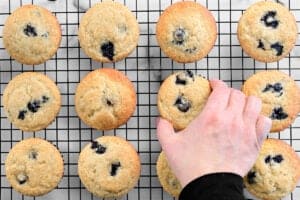 a hand setting a muffin down on a cooling rack