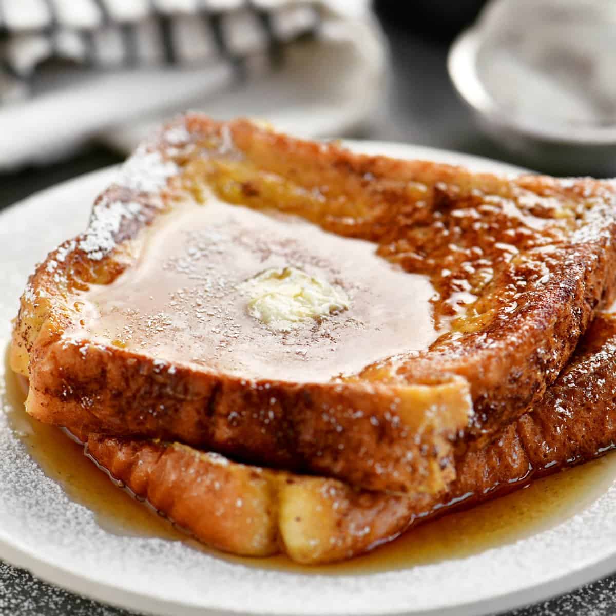 two slices of french toast on a plate with syrup and butter on top