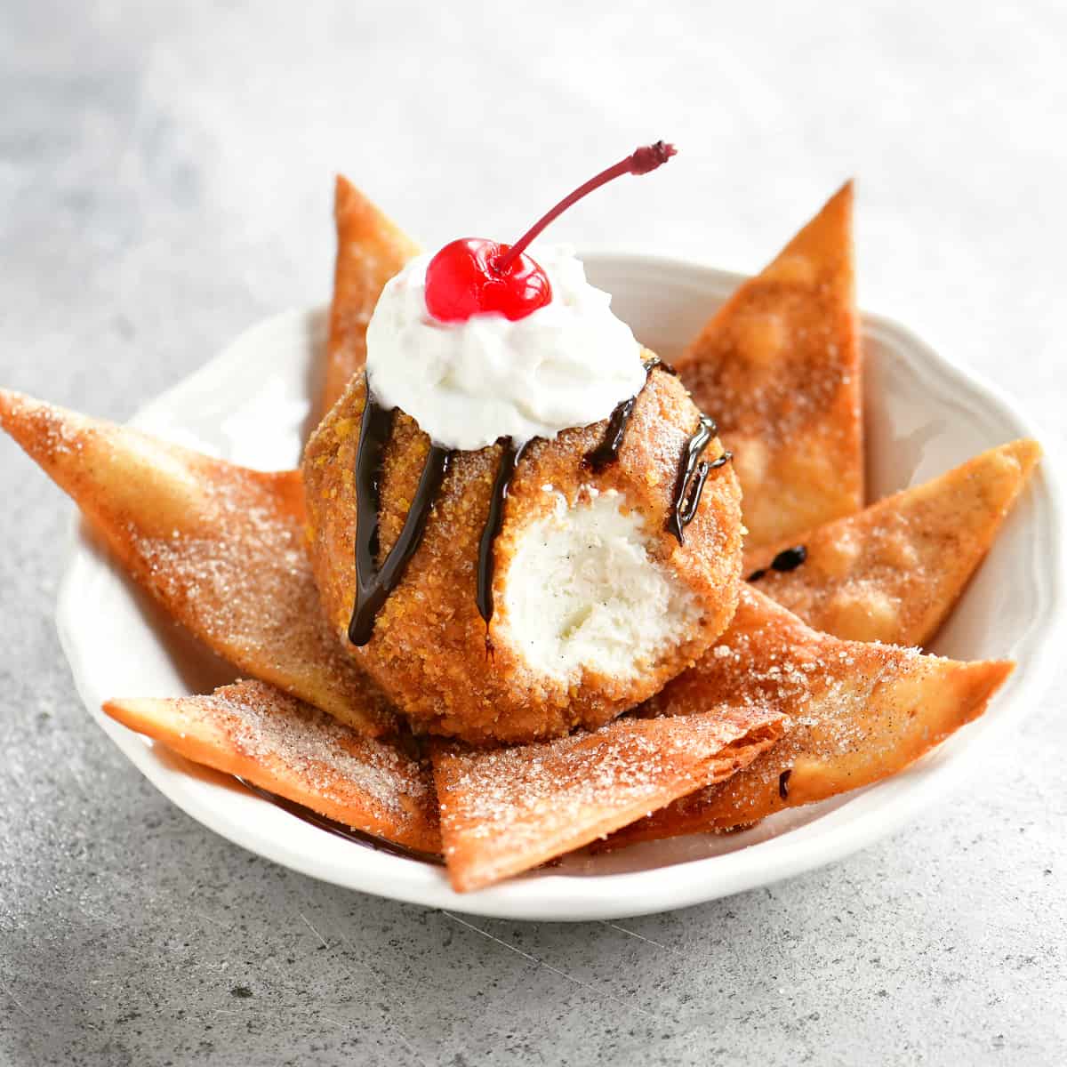 fried ice cream in a white bowl with cinnamon tortilla chips