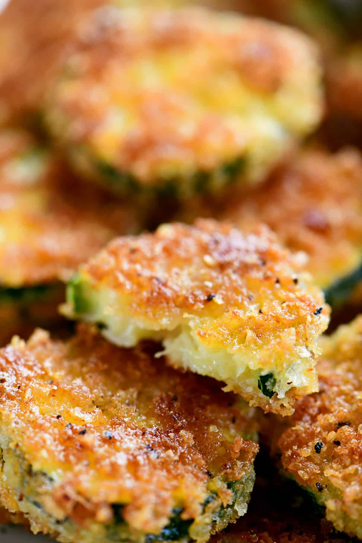 a breaded fried zucchini slice with a bite out of it