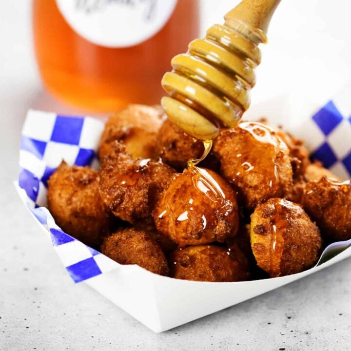 drizzling honey on a tray of hushpuppies